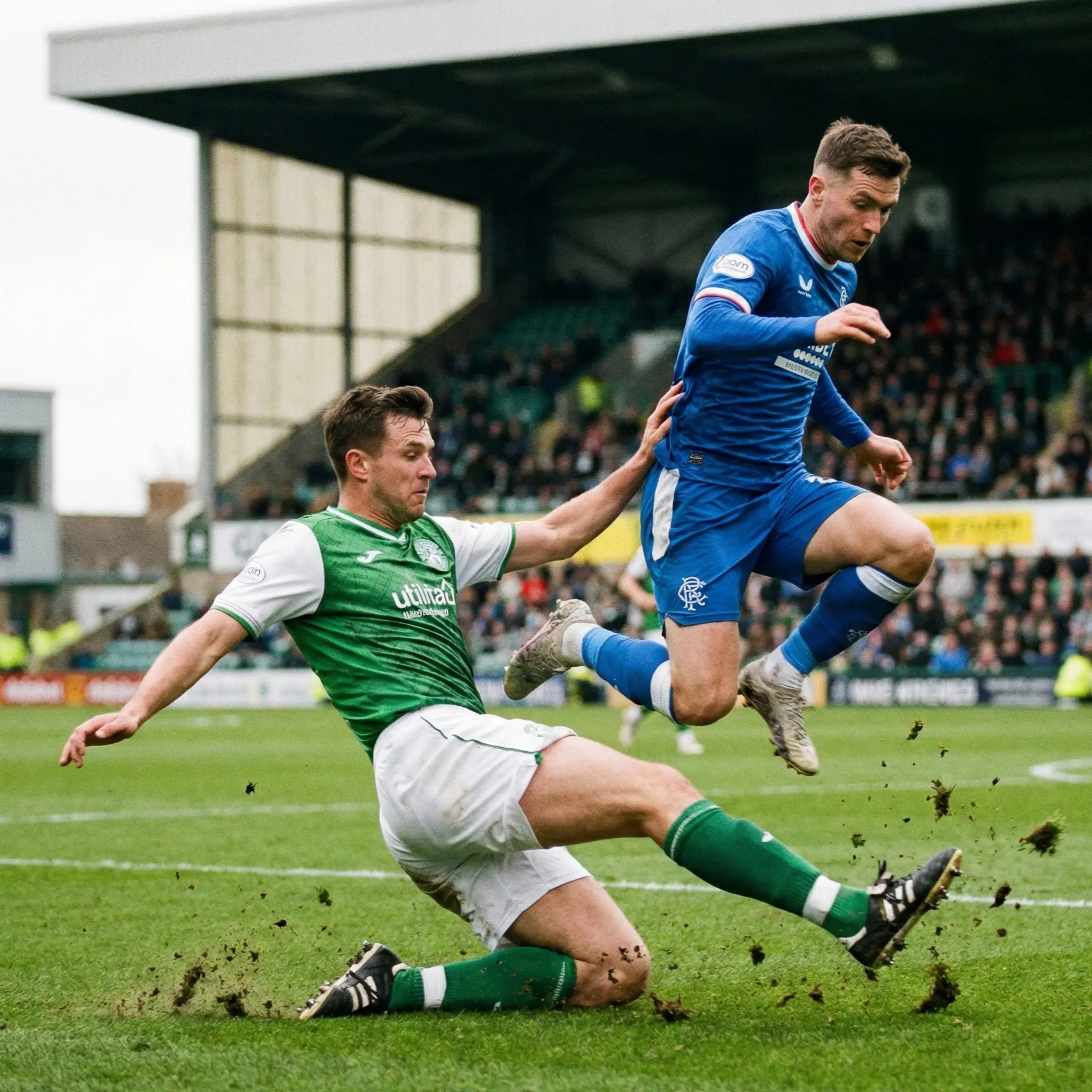 Defensive midfielder making a sliding tackle on grass pitch