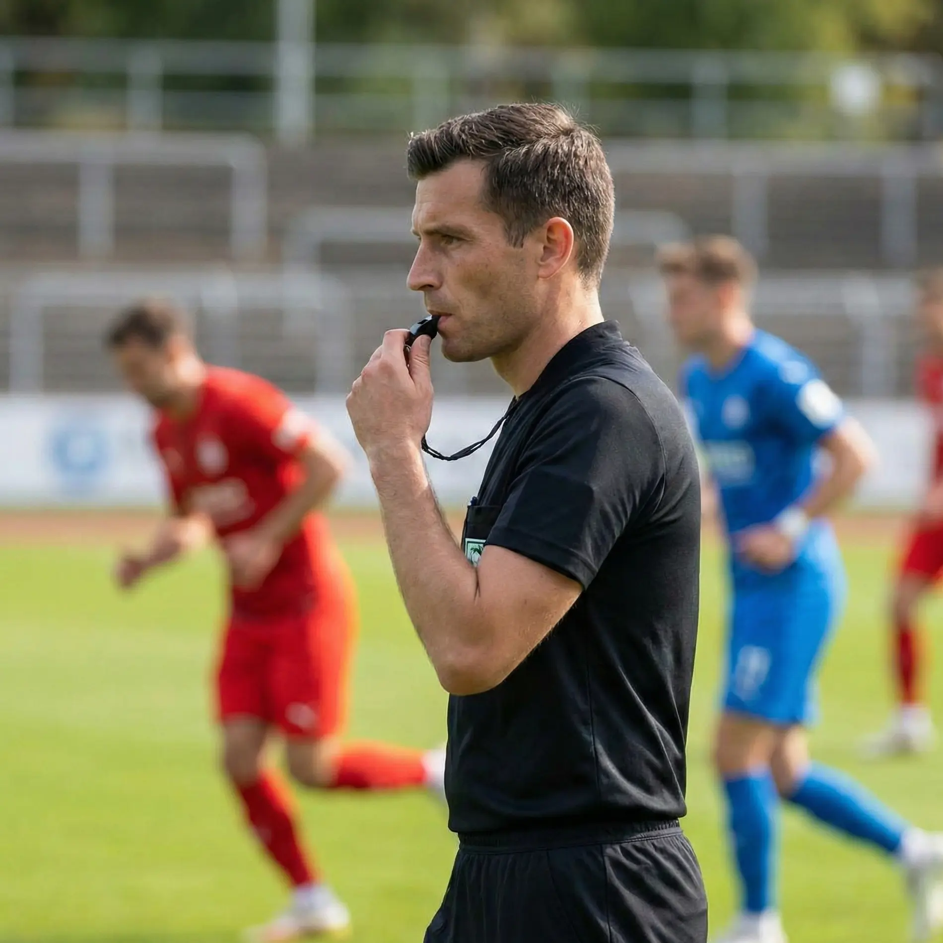 Football referee watching players closely during match